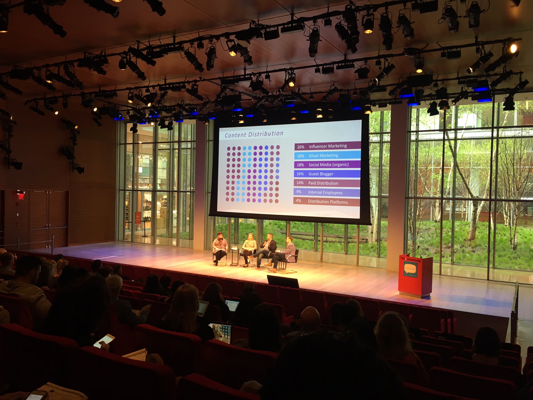 A conference audience watching Ryan Saghir and fellow panelists.